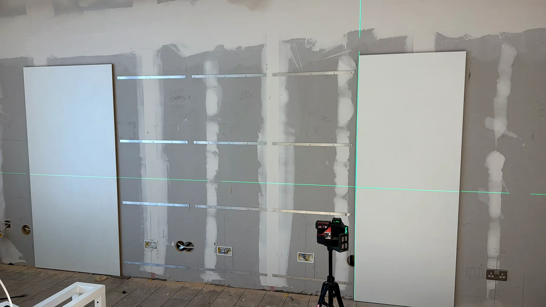 Perete interior cu doze, cabluri si nivel laser pentru pregatirea instalatiei electrice.